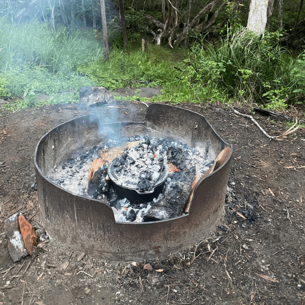 Pizza cooking in campoven in camp fire while out in the bush