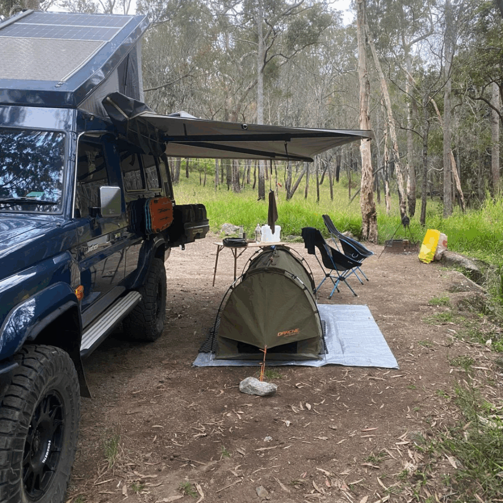 Swag under canvas awning while out camping with blue troopy